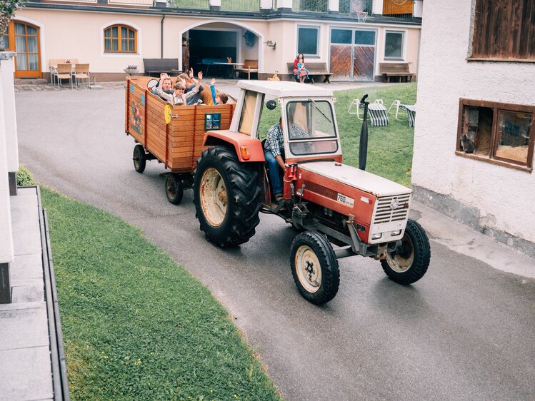 Traktorfahrt mit Bauer Anton am Maurachhof in St. Johann - Salzburger Land. Kinder im Anhänger haben Spaß. | © Urlaub am Bauernhof Salzburger Land / Daniel Gollner