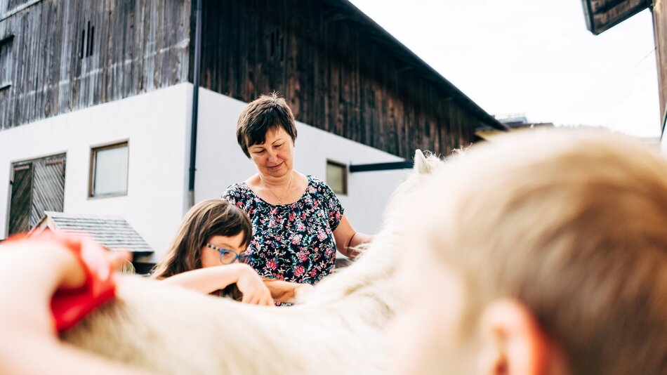 Angelika Kaltenhauser zeigt den Kindern, wie man das Pony striegelt. | © Urlaub am Bauernhof im SalzburgerLand / Daniel Gollner