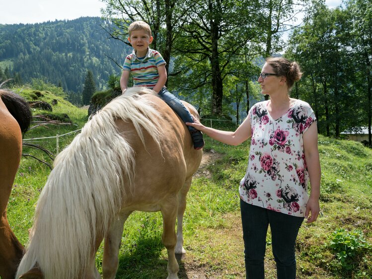 Ein kleiner Bub sitzt auf einem Pferd am Vorderfrommhof in Werfenweng. | © Urlaub am Bauernhof im SalzburgerLand / Matthias Gruber