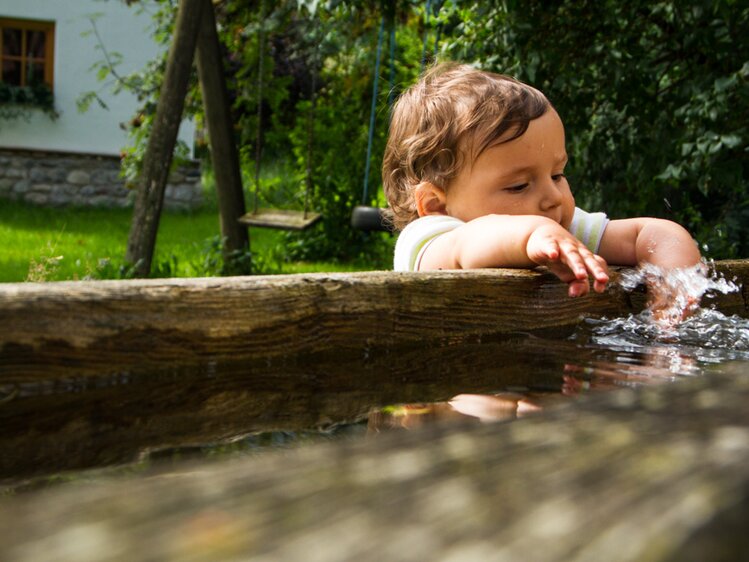 Kind am Brunnen am Zieferhof in Leogang, Salzburger Land | © Urlaub am Bauernhof / Matthias Gruber