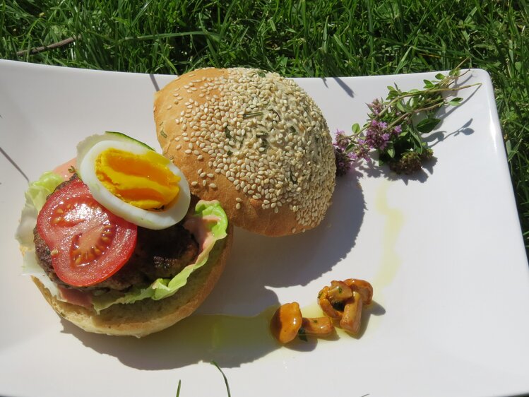 Wildburger mit selbstgemachtem Burgerbrötchen und Wildfaschiertem schön auf dem Teller angerichet. Windhofgut Annaberg, Salzburger Land | © Andrea Schilchegger