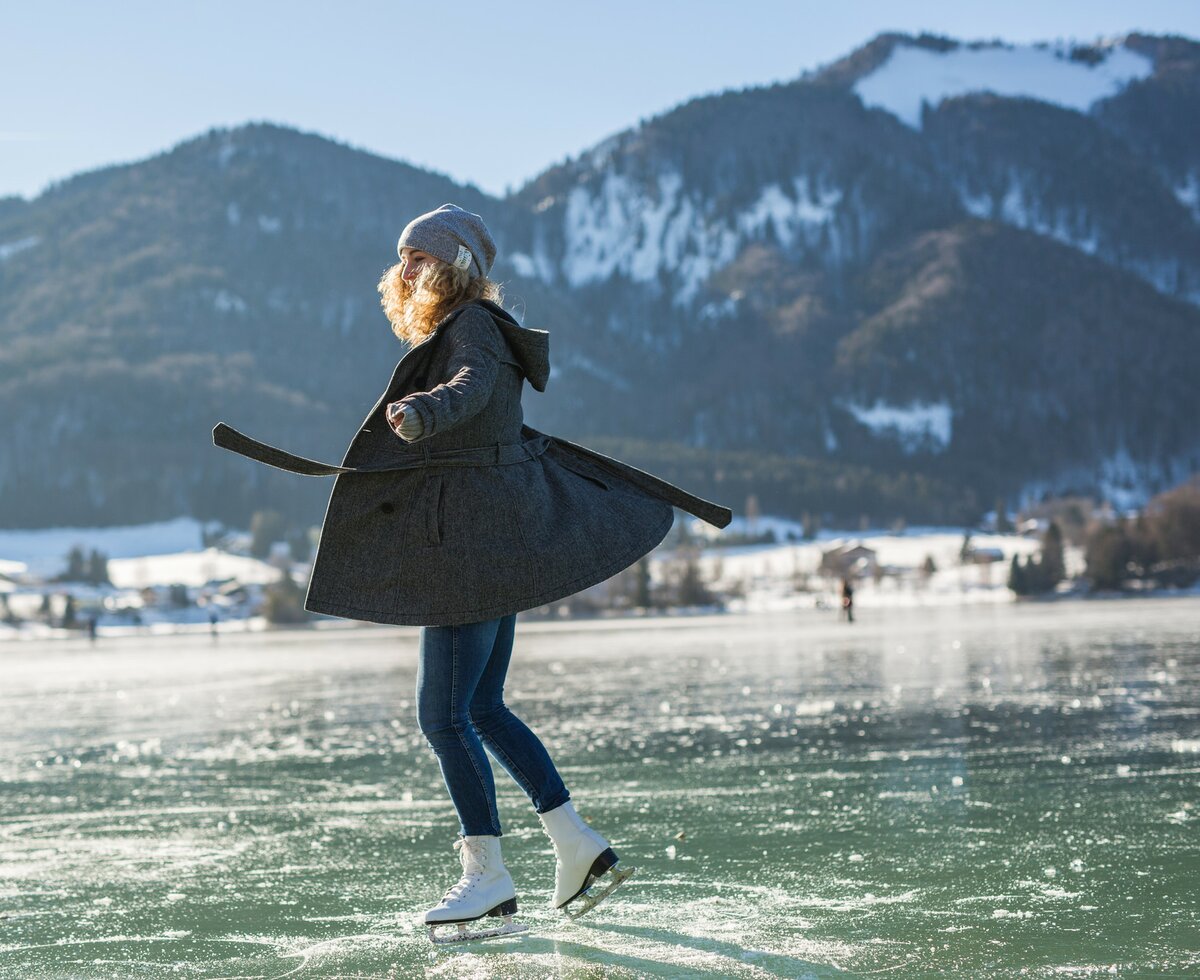 Eine junge Frau fährt auf Schlittschuhen über den Fuschlsee im SalzburgerLand. | © SLT / Michael Groessinger