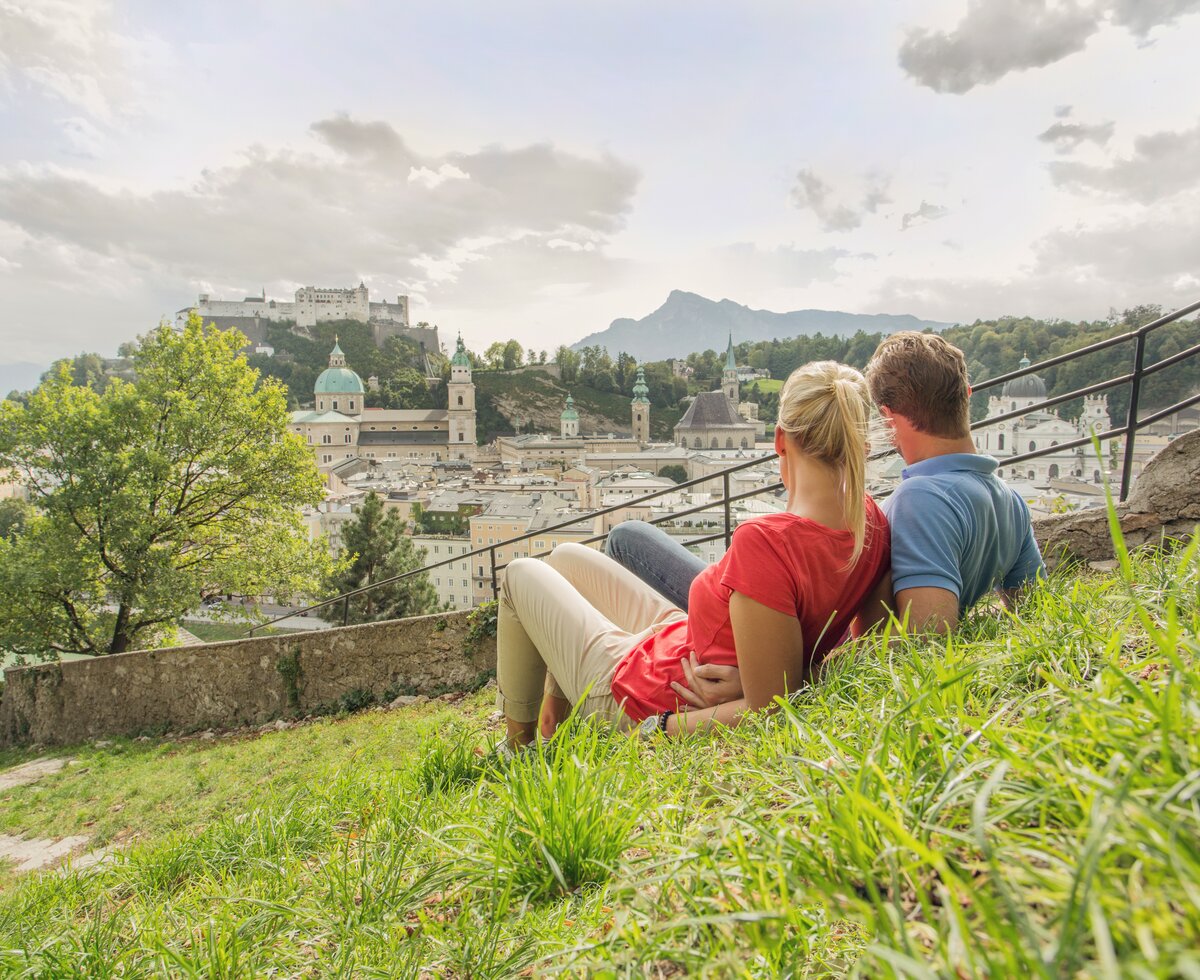 Ein Pärchen genießt den Blick auf die Altstadt von Salzburg vom Kapuzinerberg aus. | © SalzburgerLand Tourismus / Eva triff.