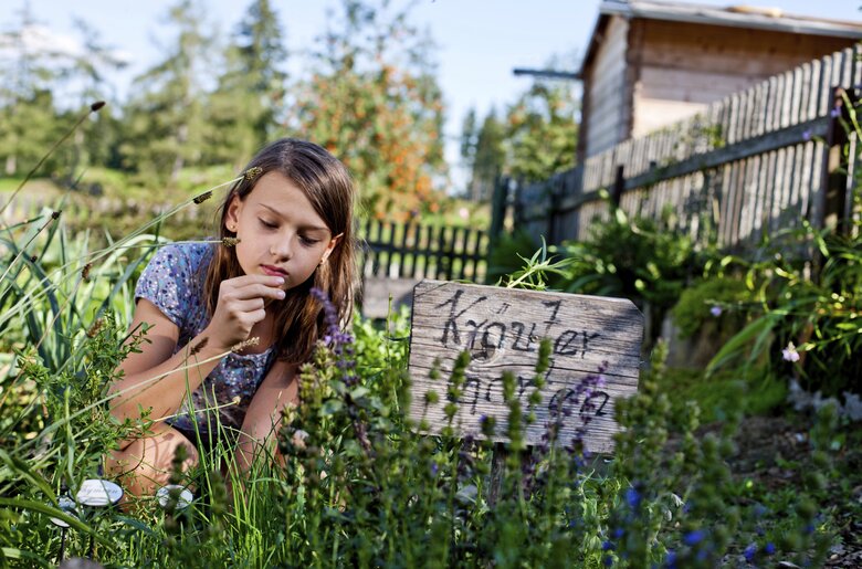 Mädchen riecht im Kräutergarten an den Kräutern, Urlaubsregion Murau-Murtal, Steiermark | © Urlaub am Bauernhof Steiermark / Kufferath