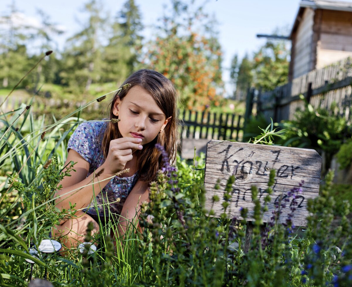 Mädchen riecht im Kräutergarten an den Kräutern, Urlaubsregion Murau-Murtal, Steiermark | © Urlaub am Bauernhof Steiermark / Kufferath