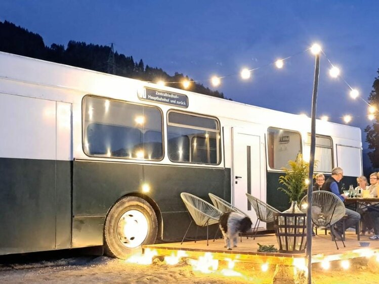 Auf der Terrasse des Glampingbus Lindwurm sitzen abends die Gäste und genießen die Ruhe | © Familie Lutzmann / Katrin Lutzmann