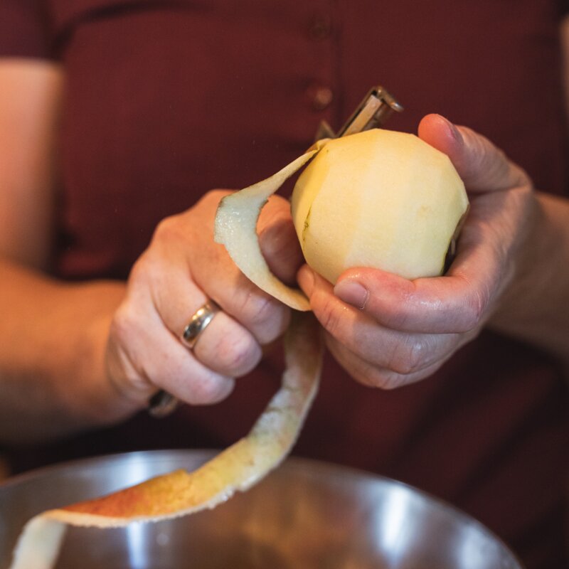 Bäuerin beim Apfelschälen für den Apfelstrudel, Steiermark | © Urlaub am Bauernhof / Punkt & Komma