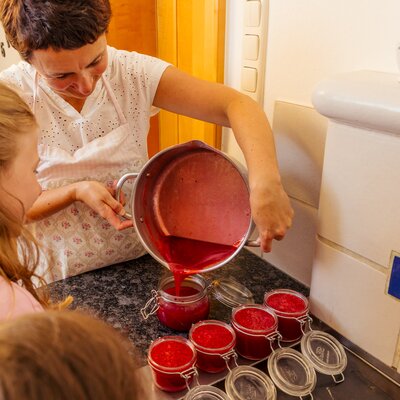 Bäuerin füllt mit Kindern frische Marmelade in Gläsern ab | © Urlaub am Bauernhof Steiermark / Wolfgang Spekner