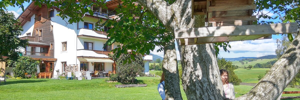 Vogerlhäuserl am Baum mit Wohnhaus im Hintergrund, Almenlandhof, Steiermark | © Urlaub am Bauernhof Steiermark / Evelyn Götz