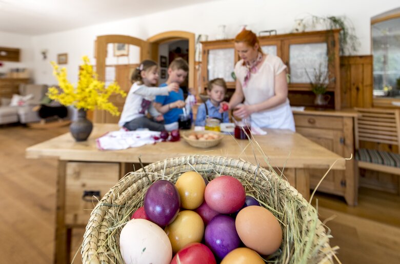 Die Kinder helfen beim Eierfärben, Korb mit gefärbten Eiern im Vordergrund, Steiermark | © Urlaub am Bauernhof Steiermark / Tom Lamm