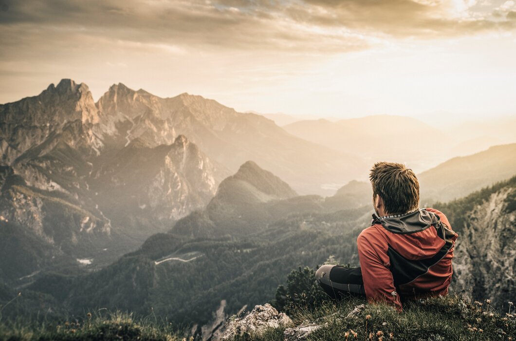 Ein Wanderer macht eine Rast und blickt auf die Berge | © TRV Gesäuse  / Stefan Leitner