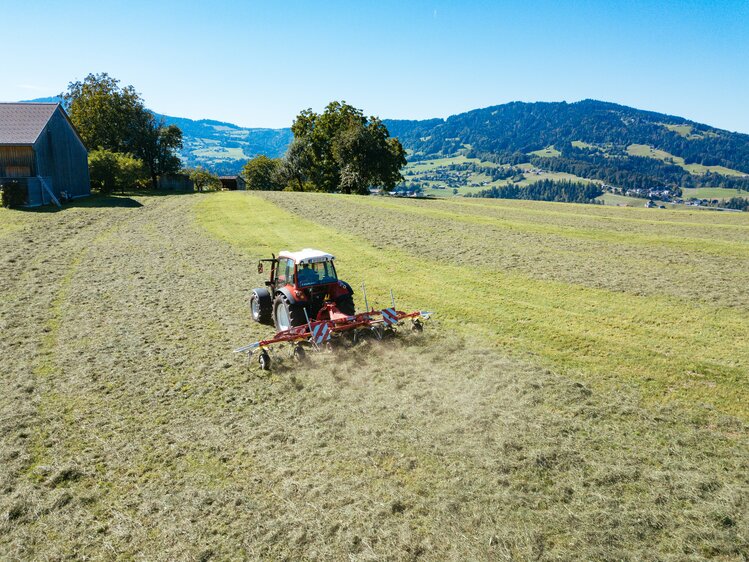 Bauer mit Traktor und Heuwender bei der Arbeit | © Urlaub am Bauernhof Vorarlberg / Daniel Gollner