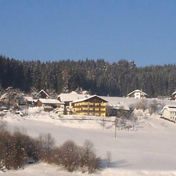 Der Bauernhof und die umliegenden Häuser in einer winterlichen, verschneiten Landschaft mit Wald im Hintergrund. Der Bauernhof und die umliegenden Häuser in einer winterlichen, verschneiten Landschaft mit Wald im Hintergrund.