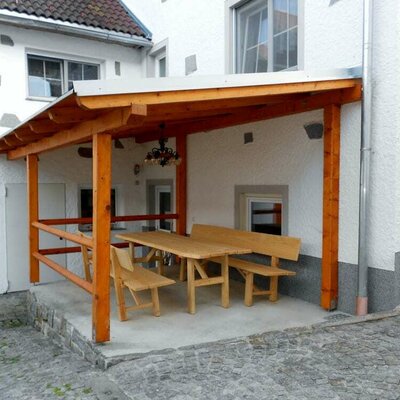 Überdachter Sitzplatz mit Tisch im Innenhof am Fuchsnhof.