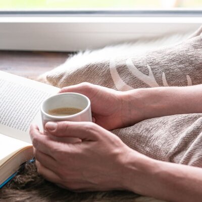 entspannter Kaffee und Buch auf Fensterbank