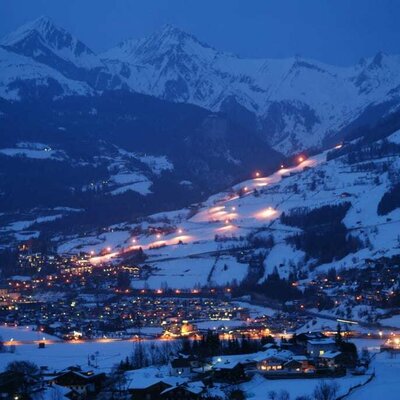 Blick vom Haus auf Matrei bei Nacht mit beleuchteter Schipiste