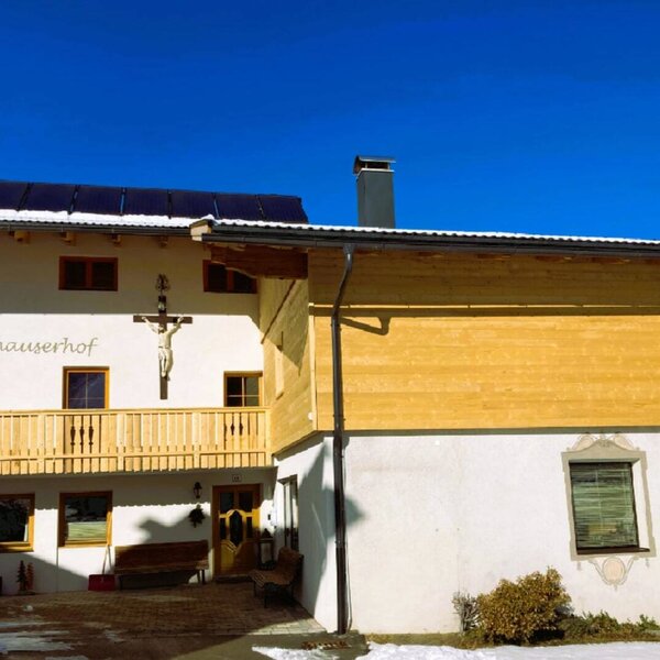 Außenansicht des Bauernhofs Neuhauserhof mit Balkonen und Solarpaneelen auf dem Dach. Außenansicht des Bauernhofs Neuhauserhof mit Balkonen und Solarpaneelen auf dem Dach.