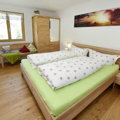 Schlafzimmer mit Doppelbett und Gitterbett