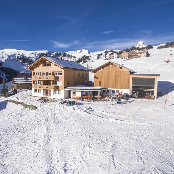 Der Bauernhof, umgeben von verschneiten Skipisten und Bergen, bietet eine Außenterrasse für Gäste. Der Bauernhof, umgeben von verschneiten Skipisten und Bergen, bietet eine Außenterrasse für Gäste.